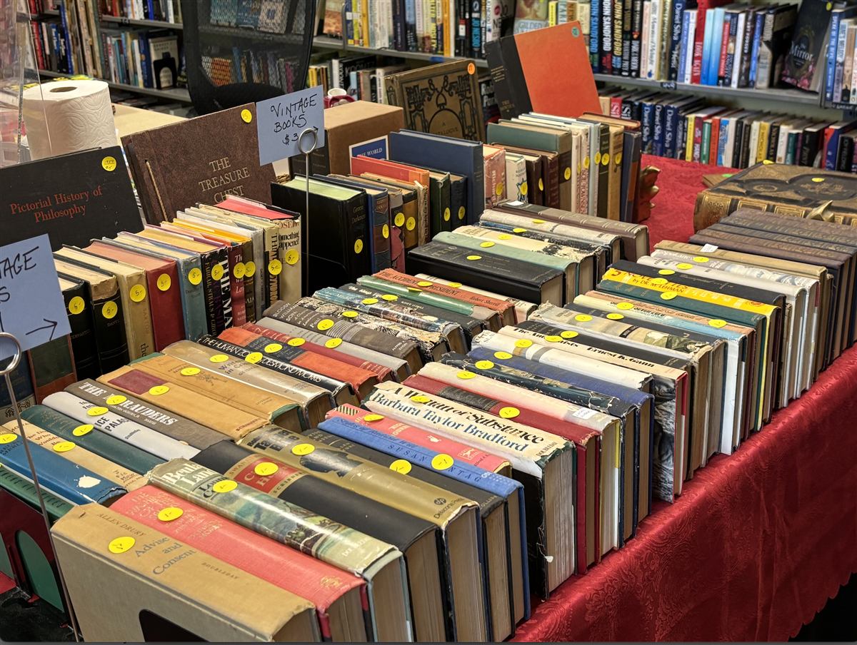 A table of vintage donated books with price stickers